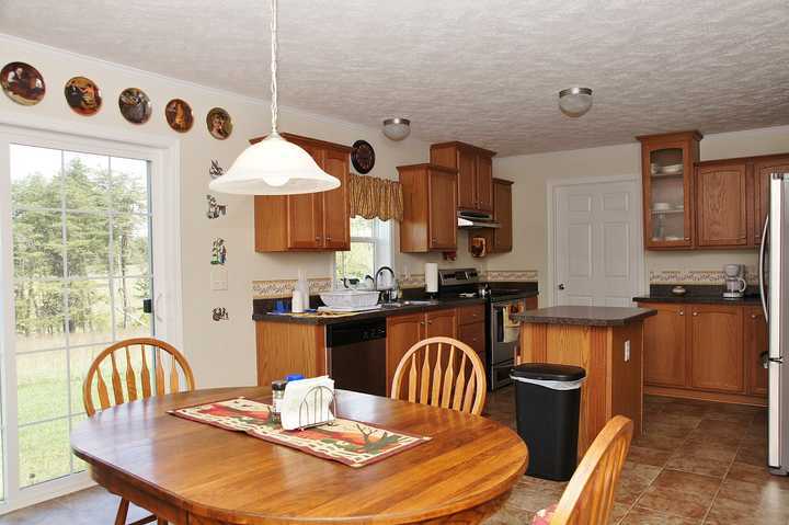 4825 Deer View Road Gretna, VA 24557 - Photo 8 of 23 a kitchen with granite countertop a stove a sink a dining table and chairs