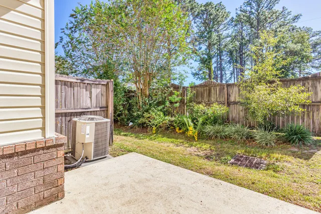 a backyard of a house with large trees and plants