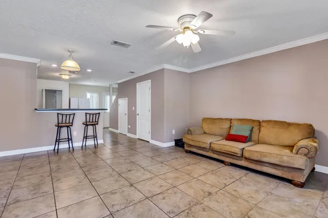 a living room with furniture and a dining table with kitchen view
