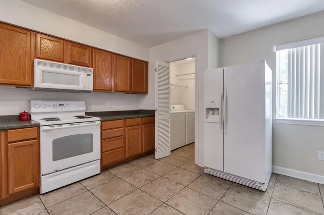 a kitchen with stainless steel appliances granite countertop a refrigerator and a stove top oven