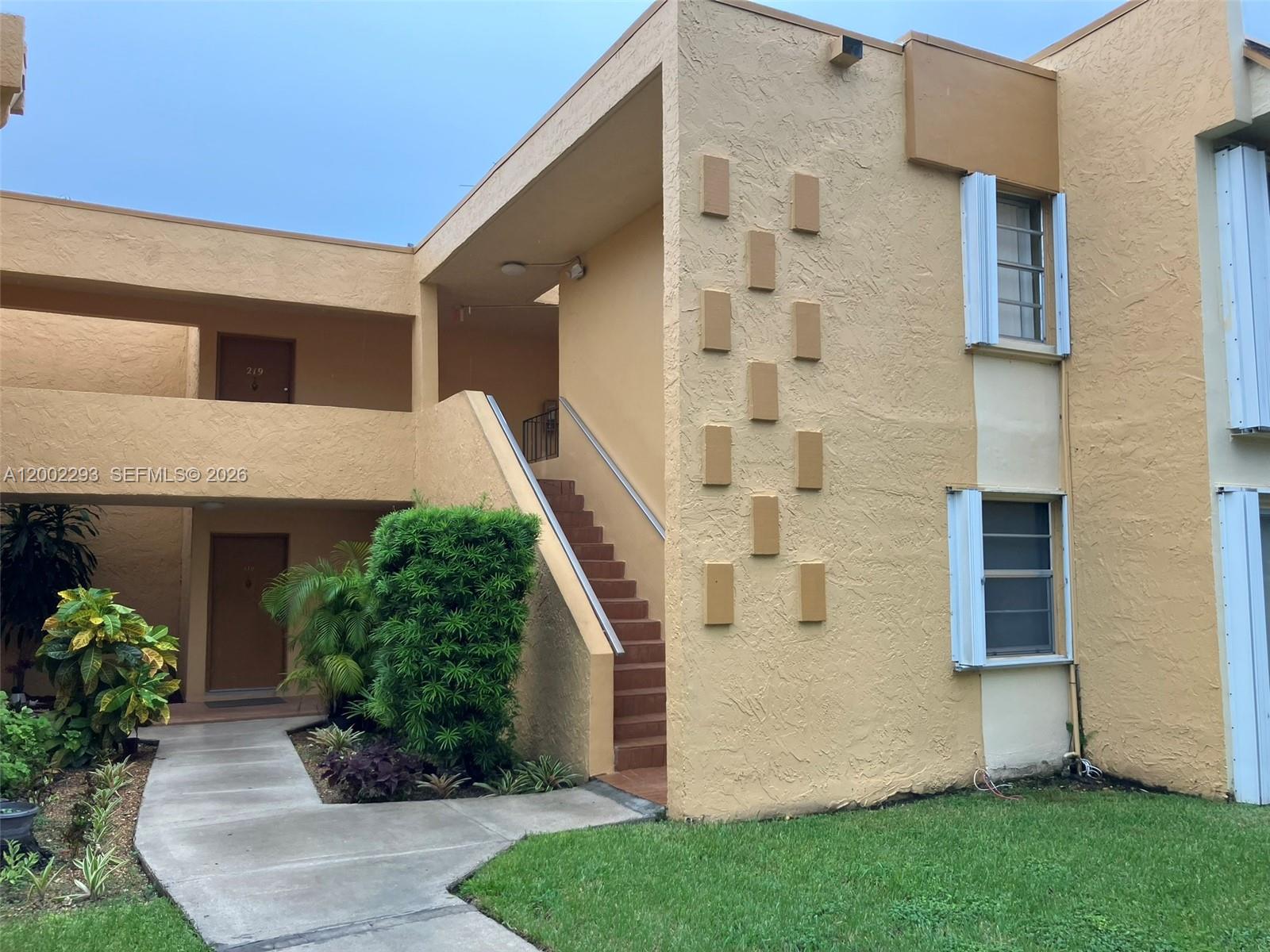 9311 Southwest 4th Street, Unit 104B Miami, FL 33174 - Photo 1 of 21 a front view of a house with a garden