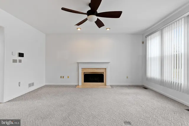 en empty room with windows and ceiling fan