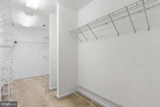 an empty room with ceiling fan and window