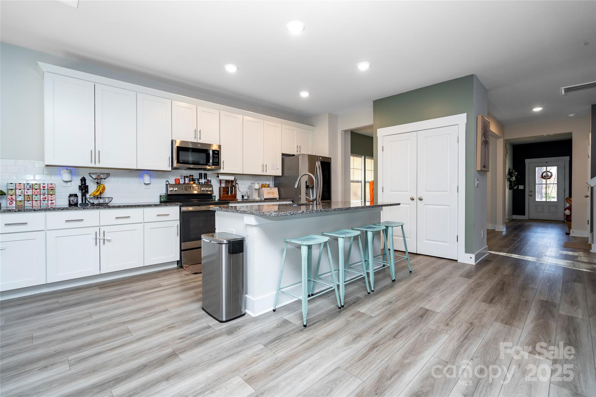 17359 Huntersville-Concord Road Huntersville, NC 28078 - Photo 7 of 41 a kitchen with kitchen island granite countertop wooden floors stainless steel appliances a sink and cabinets