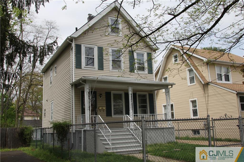 522 Front Street Dunellen, NJ 08812 - Photo 2 of 24 a view of a white house with iron fence