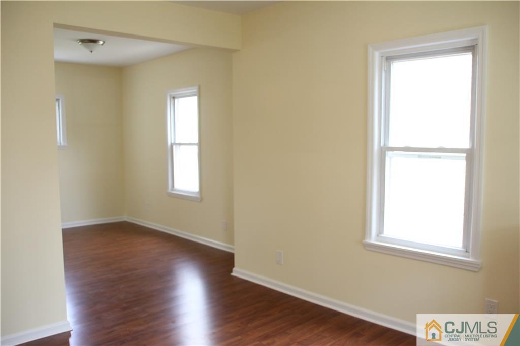 522 Front Street Dunellen, NJ 08812 - Photo 11 of 24 an empty room with wooden floor and windows