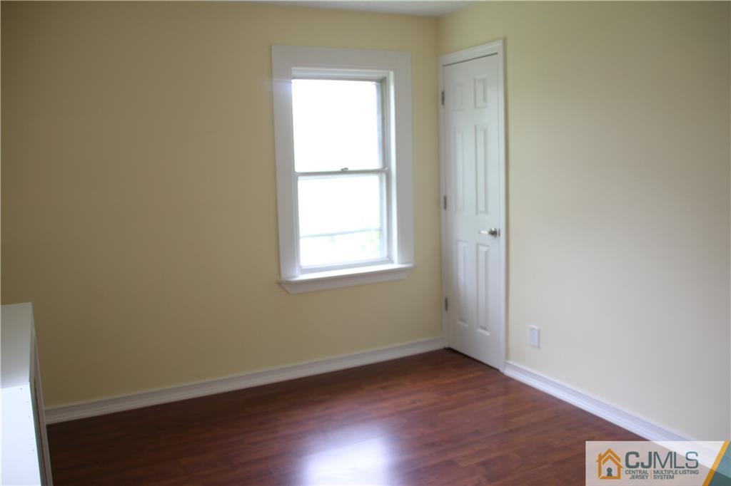 522 Front Street Dunellen, NJ 08812 - Photo 14 of 24 an empty room with wooden floor and windows