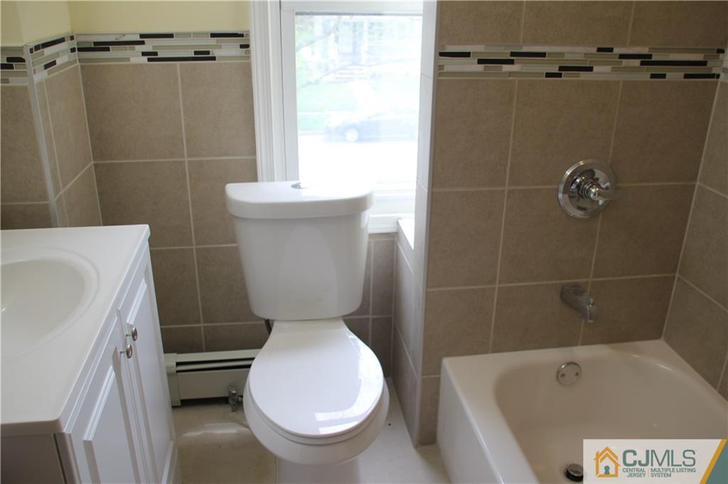 522 Front Street Dunellen, NJ 08812 - Photo 17 of 24 a white toilet sitting next to a bath tub