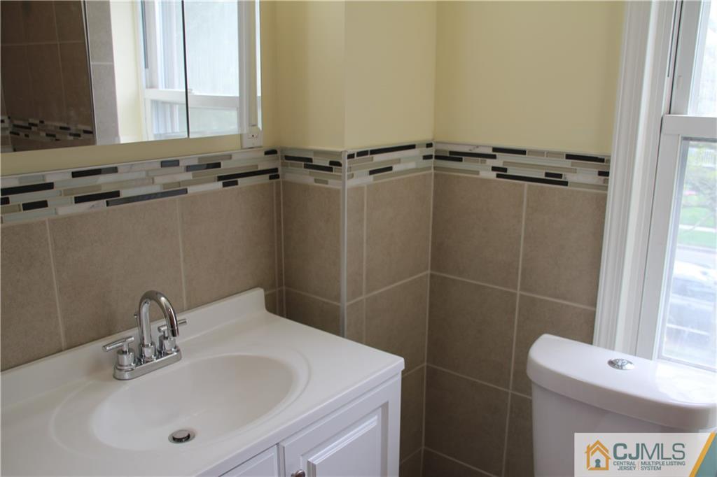 522 Front Street Dunellen, NJ 08812 - Photo 18 of 24 a bathroom with a sink a toilet and a mirror