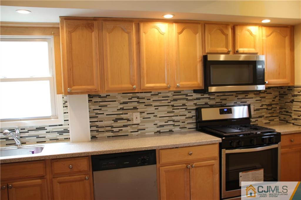 522 Front Street Dunellen, NJ 08812 - Photo 7 of 24 a kitchen with stainless steel appliances a stove a sink and a microwave
