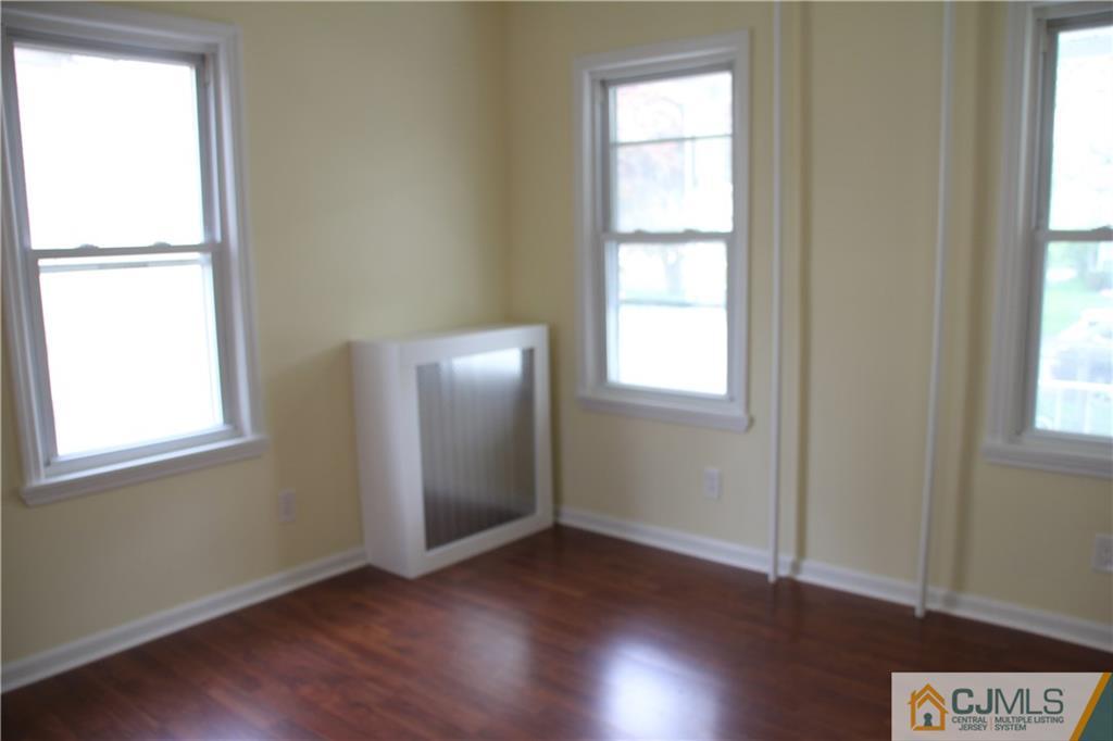 522 Front Street Dunellen, NJ 08812 - Photo 9 of 24 an empty room with wooden floor and windows