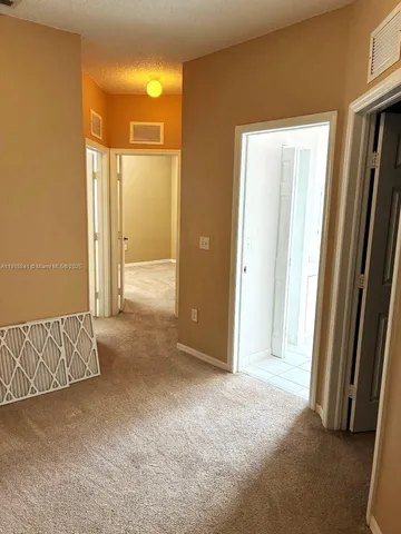 an empty room with a mirror and a wooden door