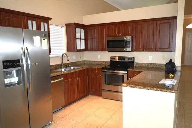 a kitchen with granite countertop stainless steel appliances and wooden cabinets