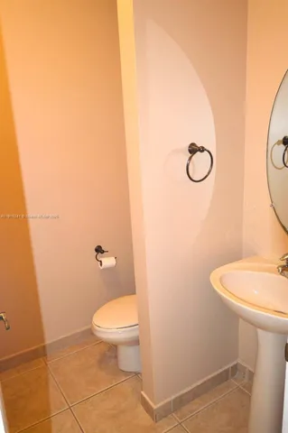 a white toilet sitting next to a bathroom sink and vanity
