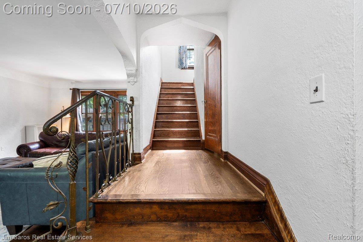 1421 Yorkshire Road Grosse Pointe, MI 48230 - Photo 14 of 29 Hardwood staircase featuring an ornate wrought iron railing
