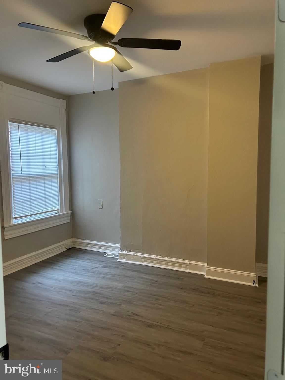 1619 1/2 Division Street Baltimore, MD 21217 - Photo 14 of 22 a view of an empty room with wooden floor and a window