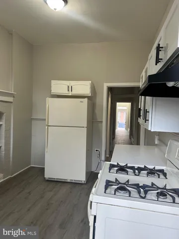 a kitchen with a white stove top oven and refrigerator