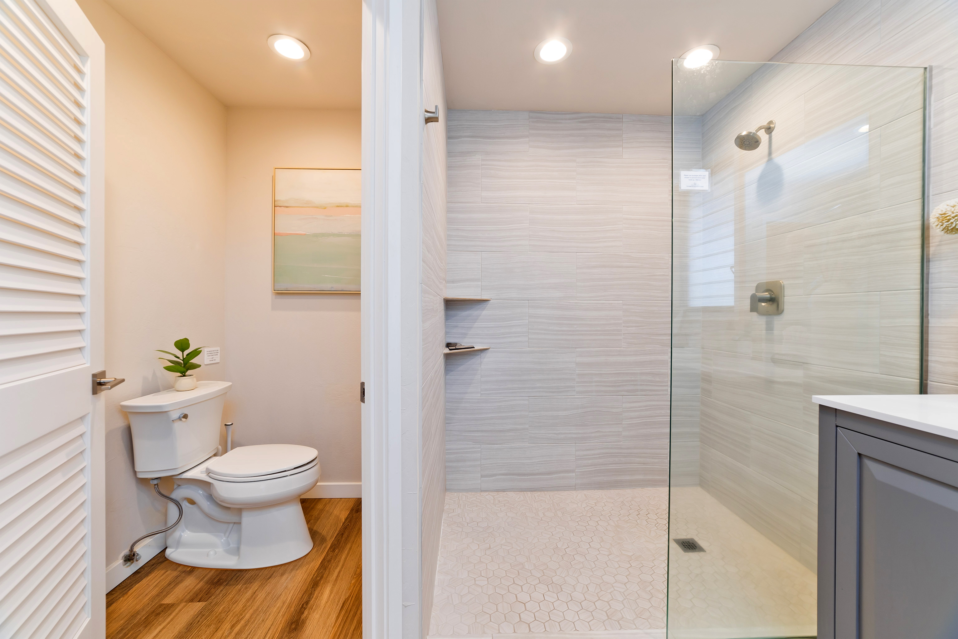 78-261 Manukai Street, Unit 303 Kailua-Kona, HI 96740 - Photo 15 of 30 a bathroom with a granite countertop toilet a sink and a shower
