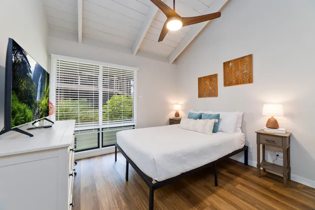 a bedroom with a bed and a large window