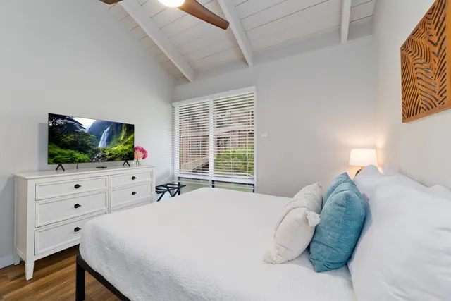 a bedroom with a bed and a flat screen tv