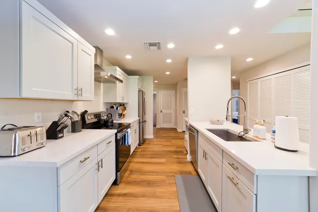 a large kitchen with stainless steel appliances granite countertop a sink and cabinets