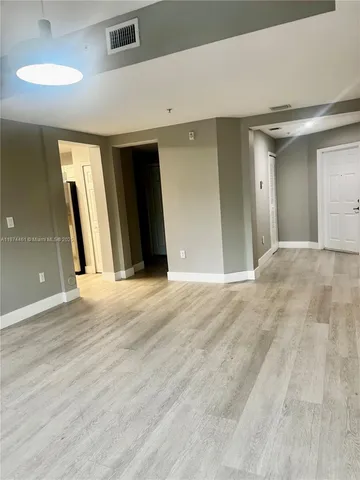 a view of a livingroom with wooden floor and a ceiling fan