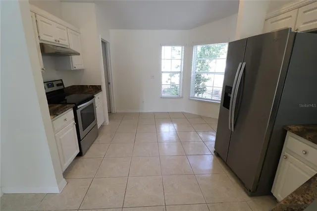 a kitchen with granite countertop a refrigerator and a stove