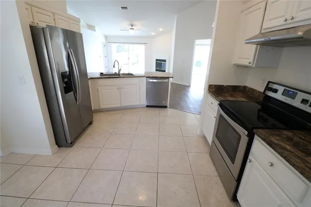 a kitchen with stainless steel appliances granite countertop a refrigerator stove and sink