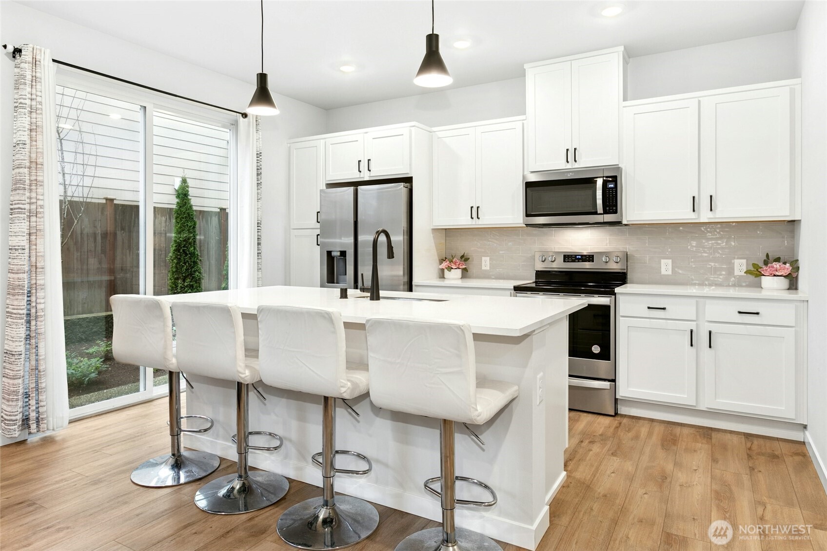 8609 Soper Hill Road, Unit G147 Marysville, WA 98270 - Photo 9 of 28 a kitchen with stainless steel appliances kitchen island granite countertop a sink a stove a refrigerator and white cabinets with wooden floor