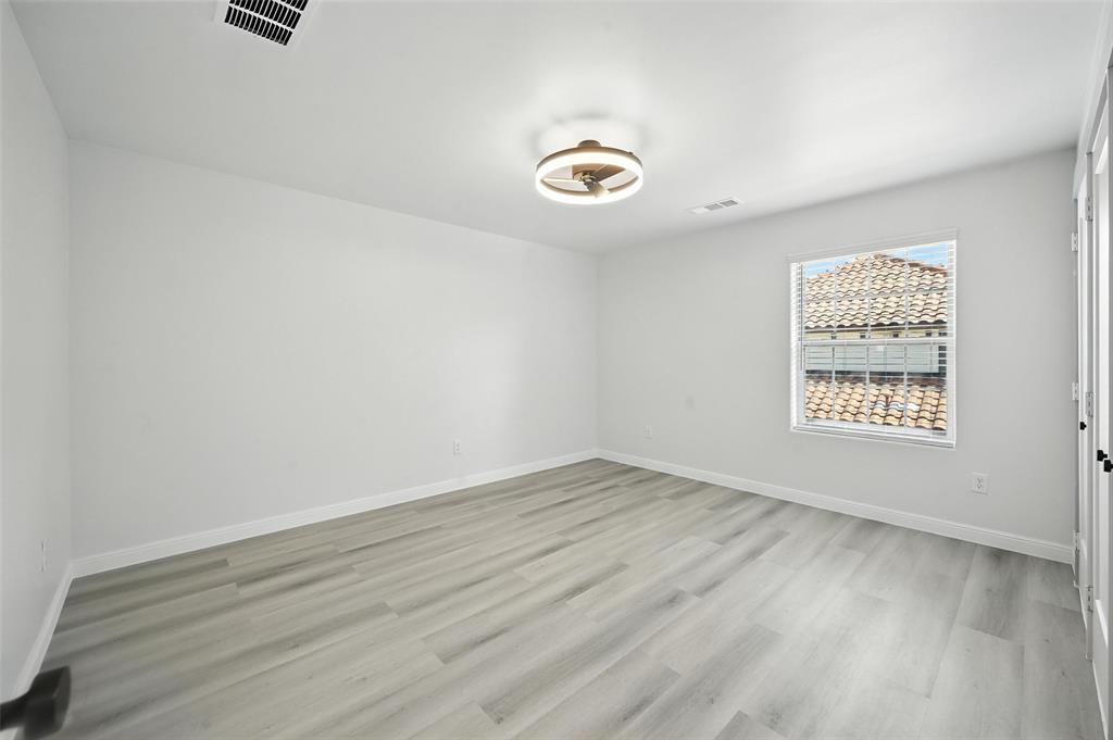 934 Elwood Road Irving, TX 75061 - Photo 19 of 40 an empty room with wooden floor and windows