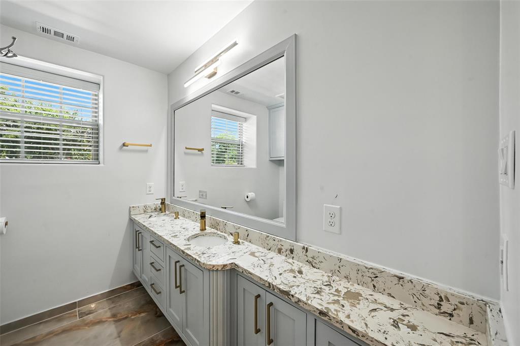 934 Elwood Road Irving, TX 75061 - Photo 30 of 40 a bathroom with a granite countertop sink and a mirror