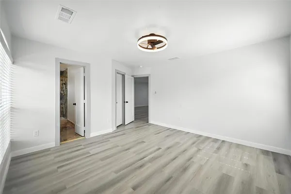 an empty room with wooden floor and a window