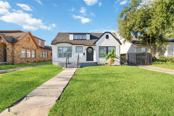 a front view of a house with a garden and plants