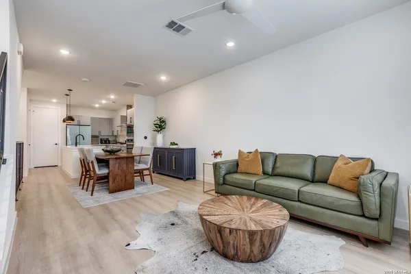a living room with furniture kitchen view and a chandelier