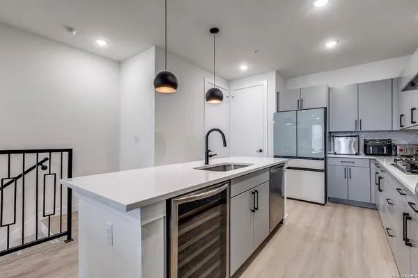 a kitchen with white cabinets appliances and sink