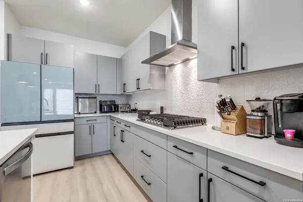 a kitchen with stainless steel appliances granite countertop a sink a stove and white cabinets