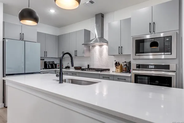 a kitchen with stainless steel appliances a stove a sink and a microwave