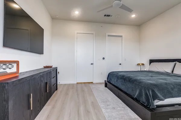 a spacious bedroom with a bed and a flat screen tv