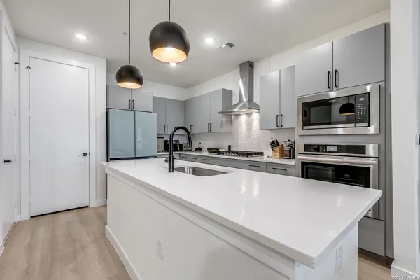 a kitchen with kitchen island a sink stainless steel appliances and cabinets
