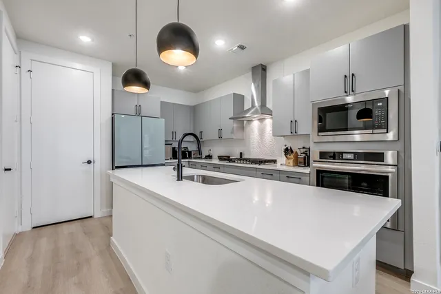 a kitchen with kitchen island a sink stainless steel appliances and cabinets