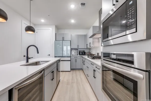 a kitchen with stainless steel appliances granite countertop a sink a stove and a refrigerator