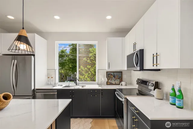 a kitchen with granite countertop a sink a counter top space appliances and cabinets