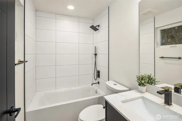 a bathroom with a tub shower sink and toilet