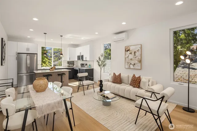 a living room with furniture and kitchen view with wooden floor
