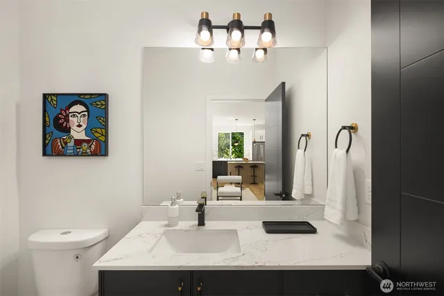 a bathroom with a sink a toilet and mirror