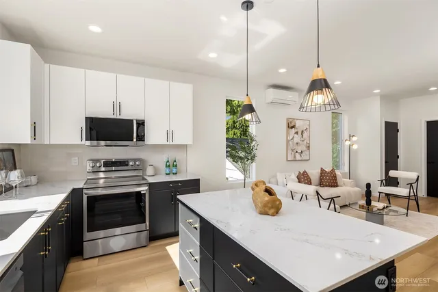 a kitchen with stainless steel appliances granite countertop a sink a stove and a wooden floors