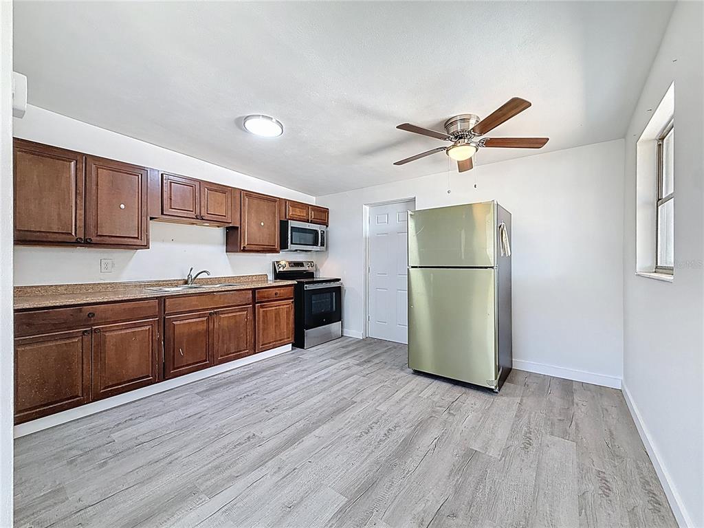 319 Leta Street Auburndale, FL 33823 - Photo 2 of 45 a kitchen with granite countertop stainless steel appliances refrigerator wooden floor and a sink