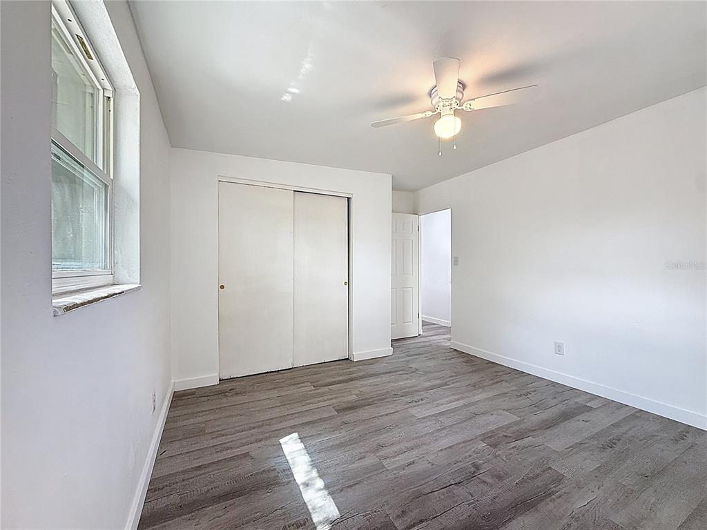 319 Leta Street Auburndale, FL 33823 - Photo 22 of 45 a view of an empty room with wooden floor and a chandelier fan