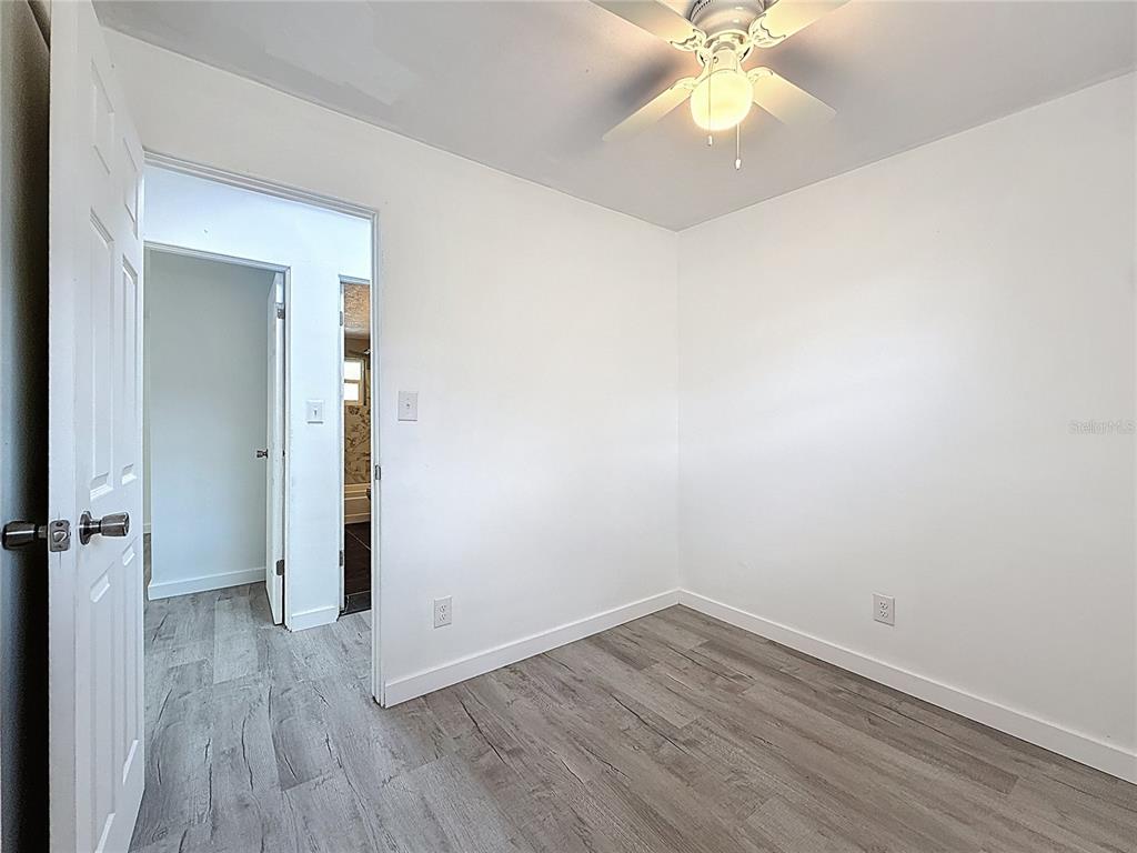 319 Leta Street Auburndale, FL 33823 - Photo 30 of 45 an empty room with wooden floor fan and windows
