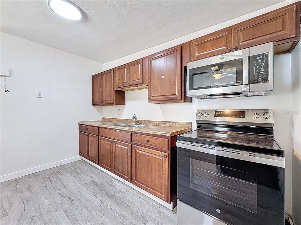319 Leta Street Auburndale, FL 33823 - Photo 4 of 45 a kitchen with stainless steel appliances a stove microwave and sink